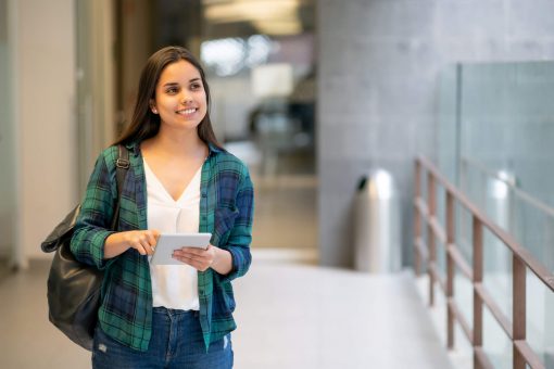 vale a pena fazer uma segunda graduação: jovem mulher em corredor de universidade