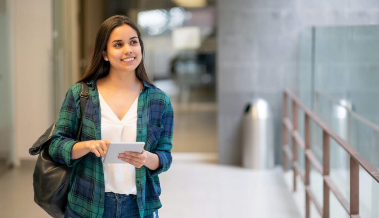 vale a pena fazer uma segunda graduação: jovem mulher em corredor de universidade